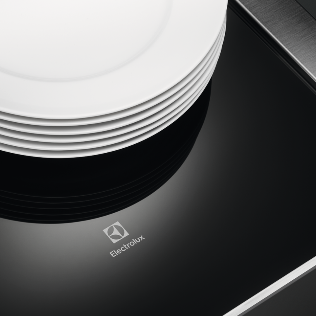 Stack of white plates on a Electrolux 600 Series Built Warming Drawer with Electrolux logo