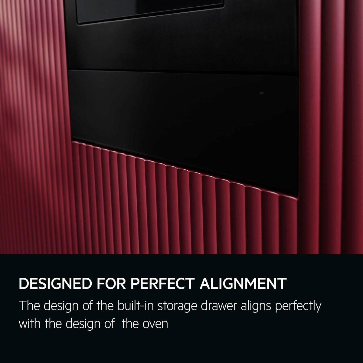 Red kitchen cabinet with AEG black built-in warming drawer and text 'Designed for perfect alignment'.