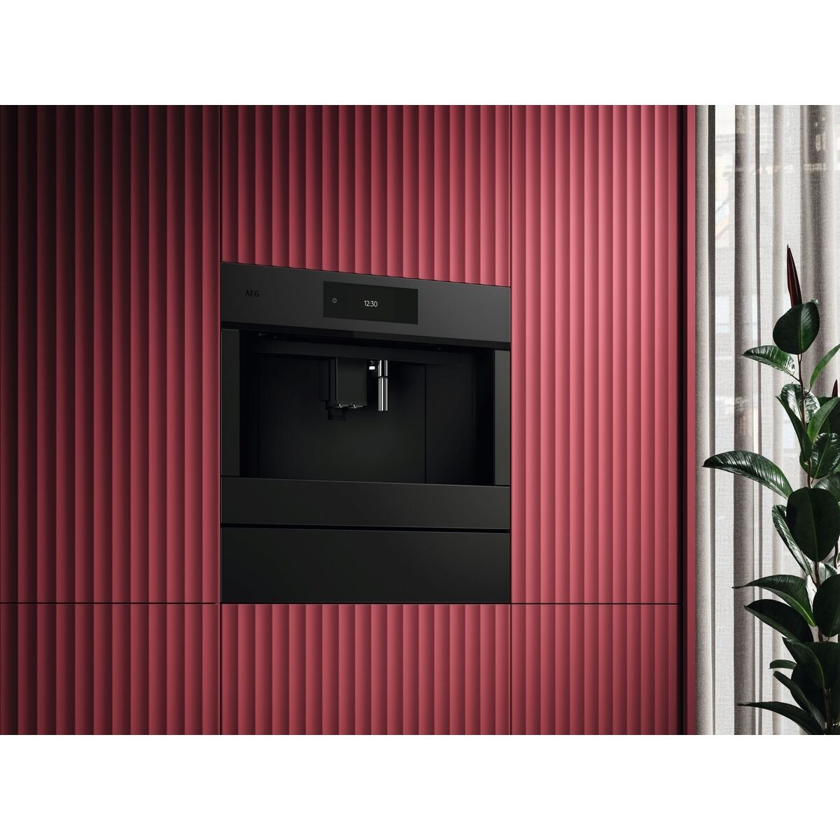 Black AEG integrated coffee machine embedded in a red ribbed wall with a plant on the right.