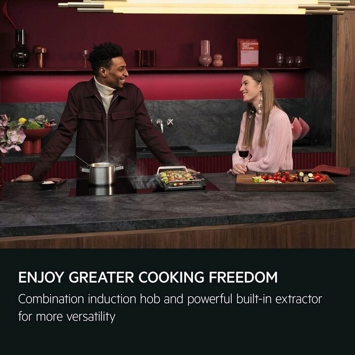 Two people in a modern AEG kitchen with a combination induction hob and built-in extractor.