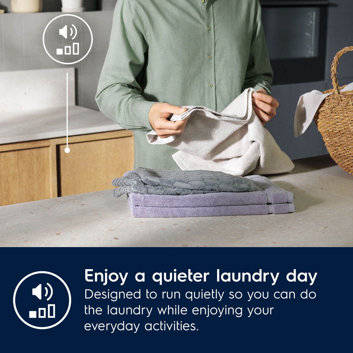 Person folding laundry in a kitchen with text about Electrolux quiet operation