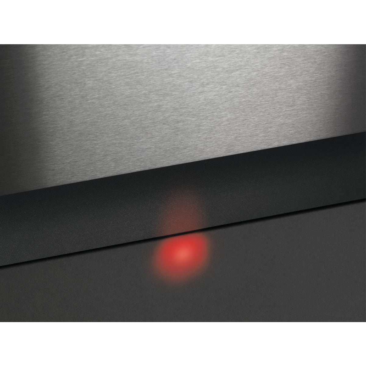 Close-up of a metallic surface with a red light source