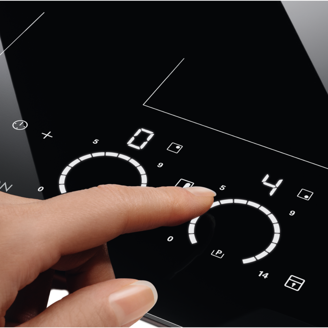 Hand interacting with a Black Electrolux induction hob 
