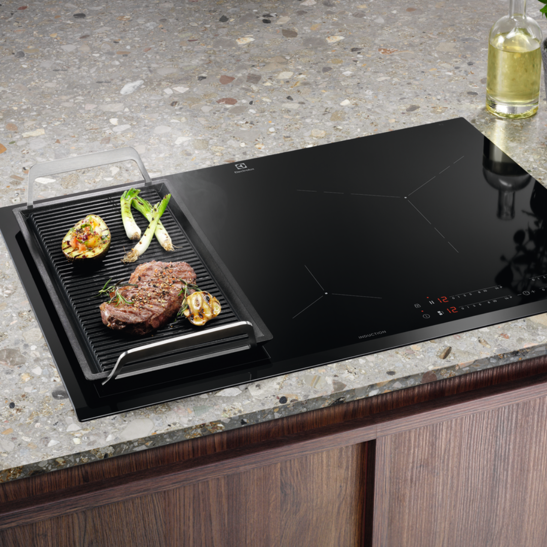 Black Electrolux induction hob with grill insert on a kitchen counter