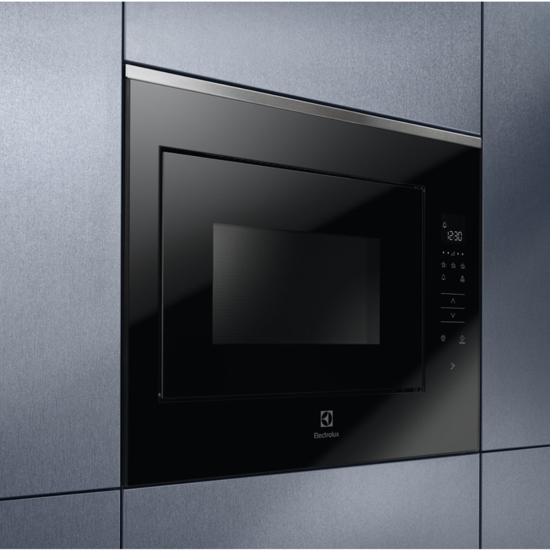 Black Electrolux built-in microwave oven on a gray tiled wall