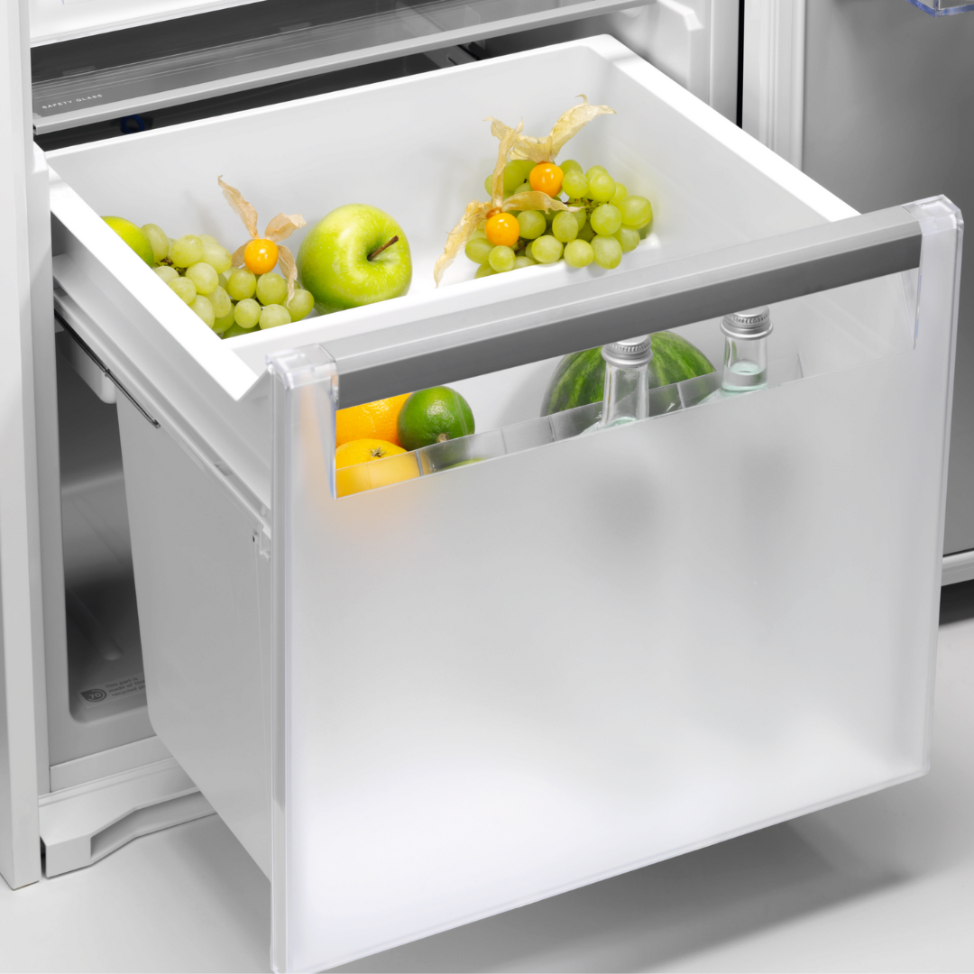 Fruit drawer in an Electrolux  refrigerator with apples, grapes, and oranges.