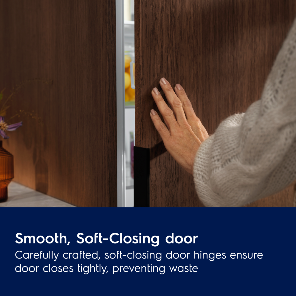 Person opening a smooth, soft-closing Electrolux Integrated Freezer door with text explaining its features.