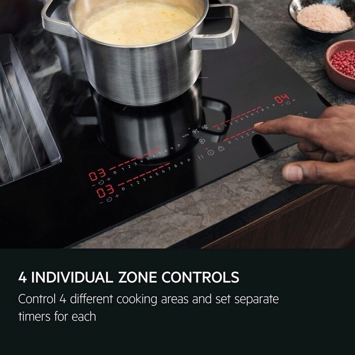 Stainless steel pot on an AEG Induction Hob with a hand adjusting the control panel.